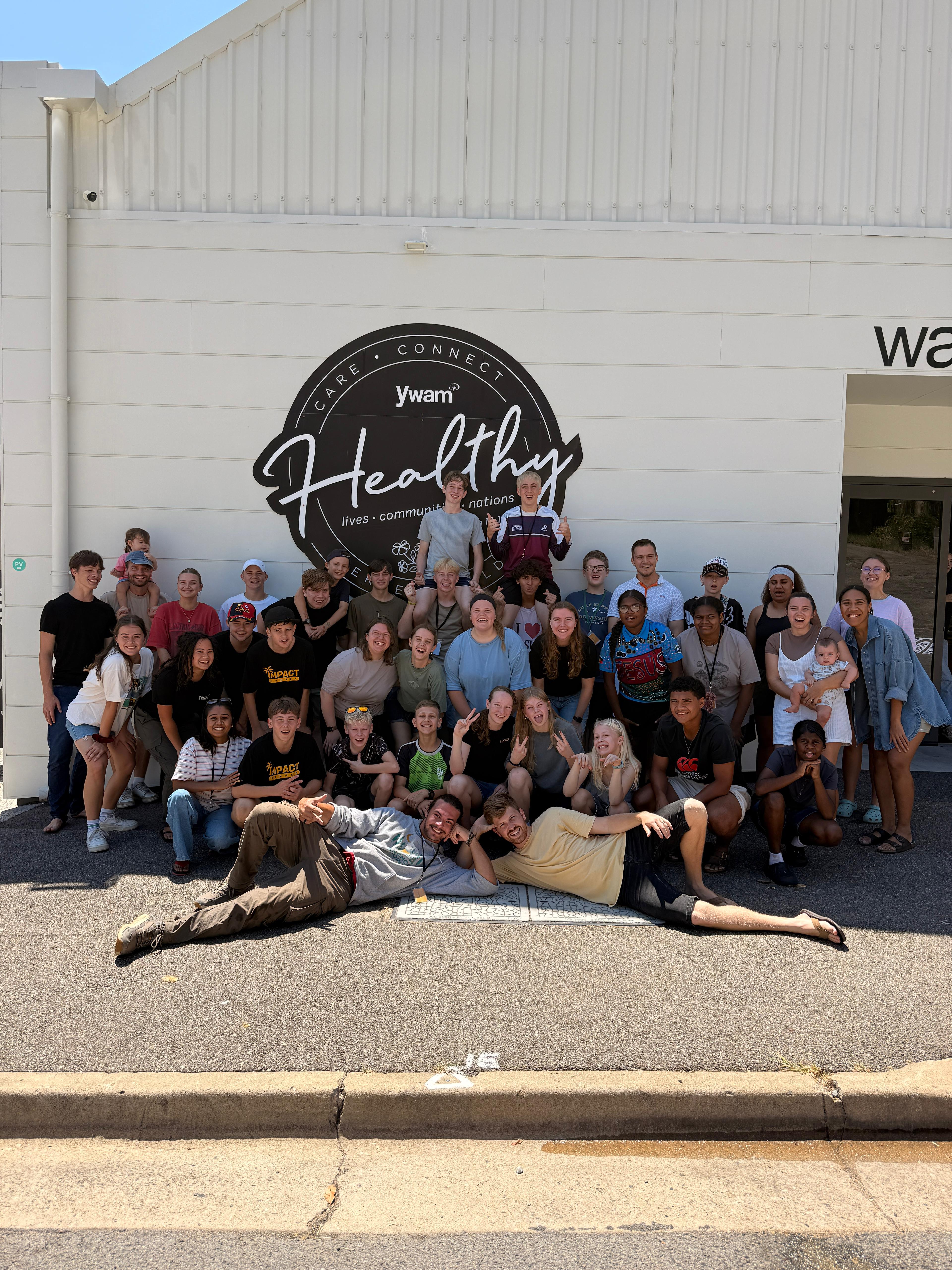 A group of young people and leaders gathered outside YWAM Healthy